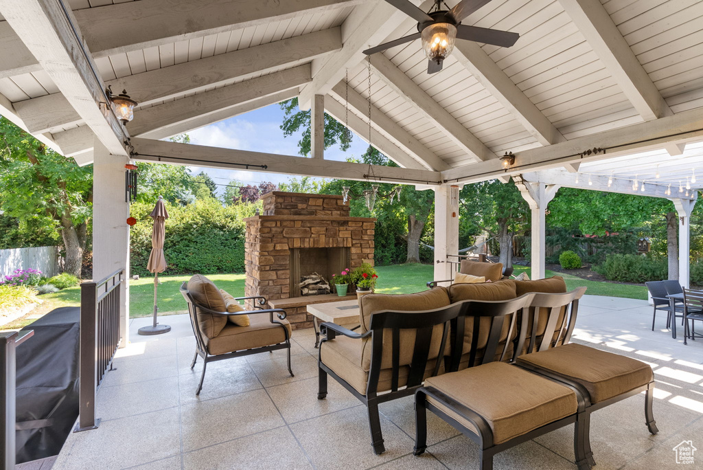 View of patio / terrace with an outdoor living space with a fireplace and ceiling fan