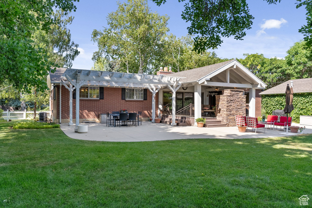 Back of property with a patio, central air condition unit, a lawn, and a pergola