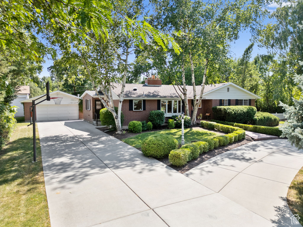 Ranch-style home featuring a garage and an outbuilding