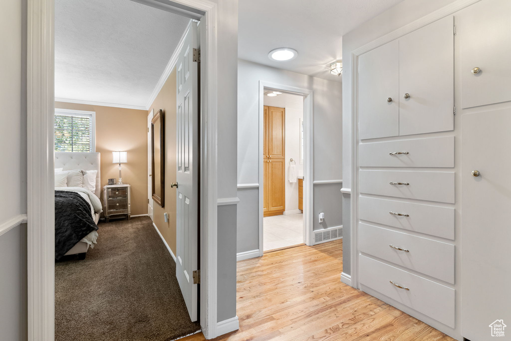 Interior space with light hardwood / wood-style flooring and ornamental molding