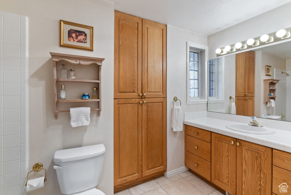 Bathroom with tile patterned floors, vanity, and toilet