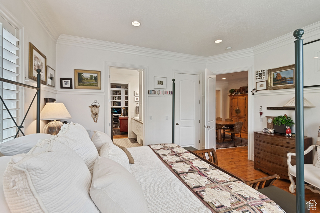 Bedroom featuring crown molding, ensuite bathroom, and hardwood / wood-style floors