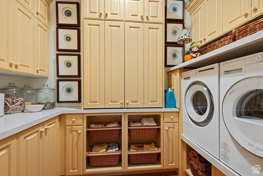 Laundry room featuring cabinets and washing machine and dryer