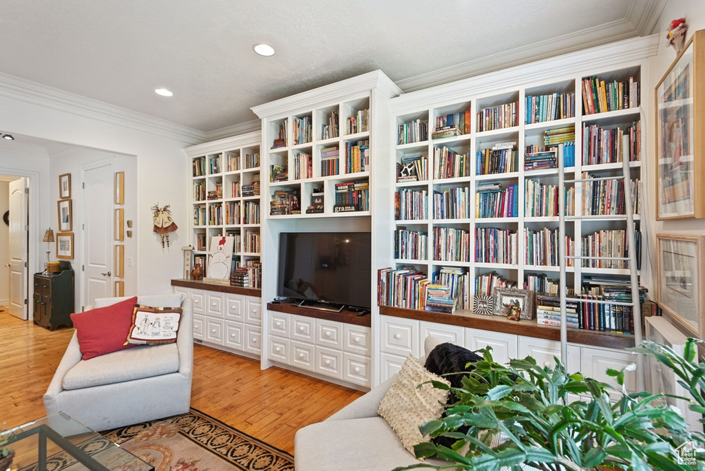 Living room featuring light hardwood / wood-style floors and crown molding