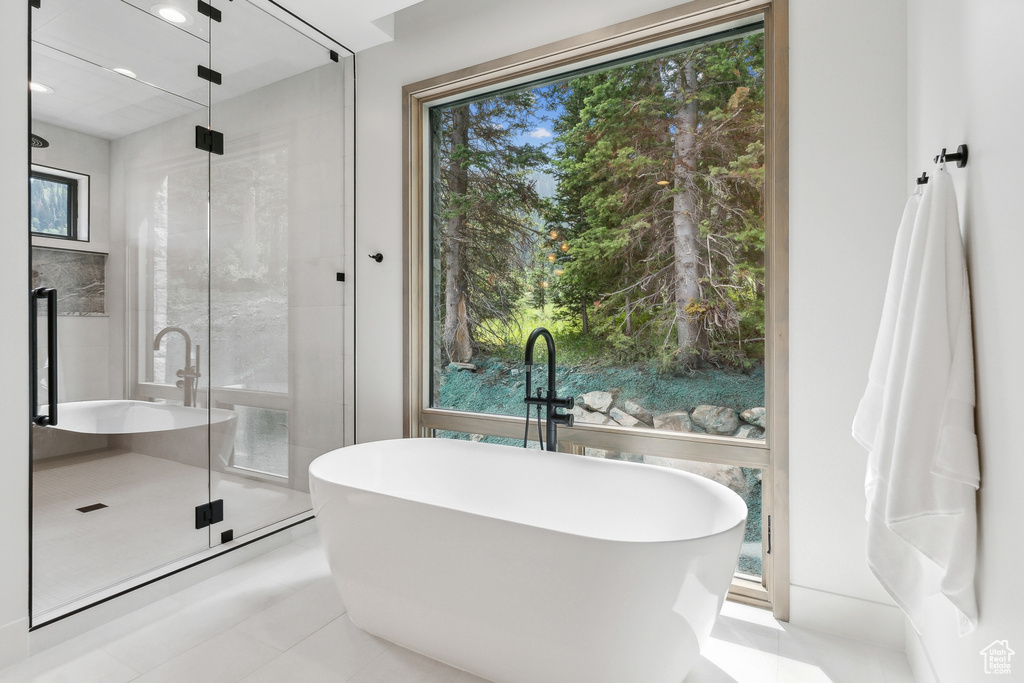 Bathroom featuring walk in shower, a healthy amount of sunlight, and tile patterned floors