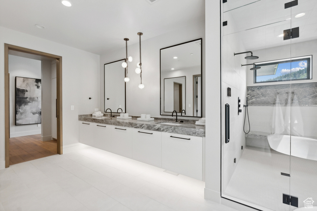 Bathroom with a shower with door, hardwood / wood-style floors, and double vanity