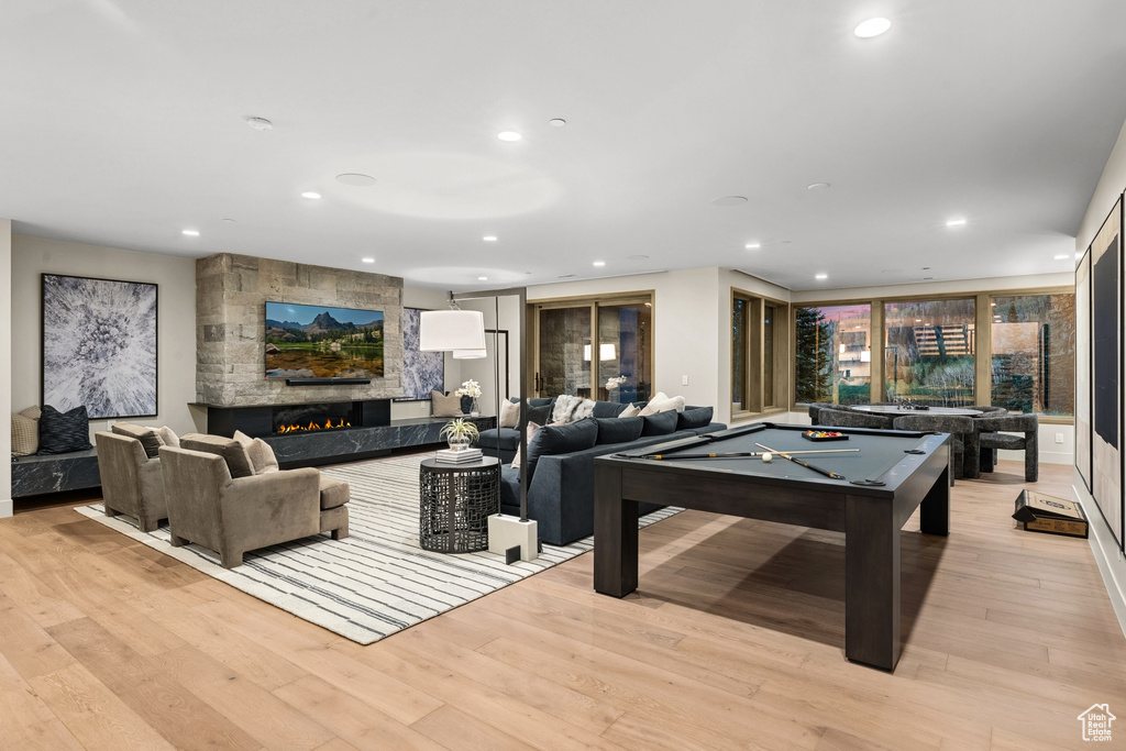 Playroom featuring light hardwood / wood-style flooring, a large fireplace, and pool table