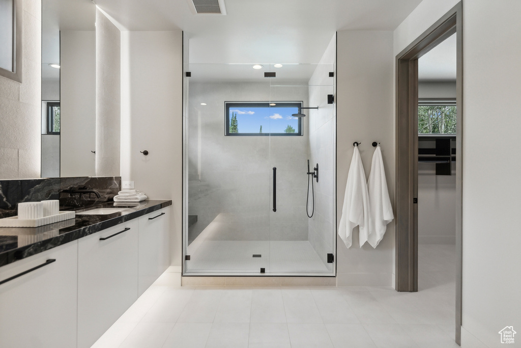 Bathroom with vanity, walk in shower, and tile patterned floors