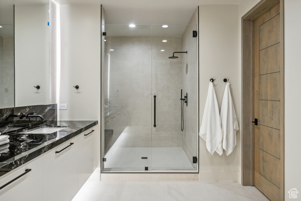 Bathroom with a shower with shower door, vanity, and tile patterned floors