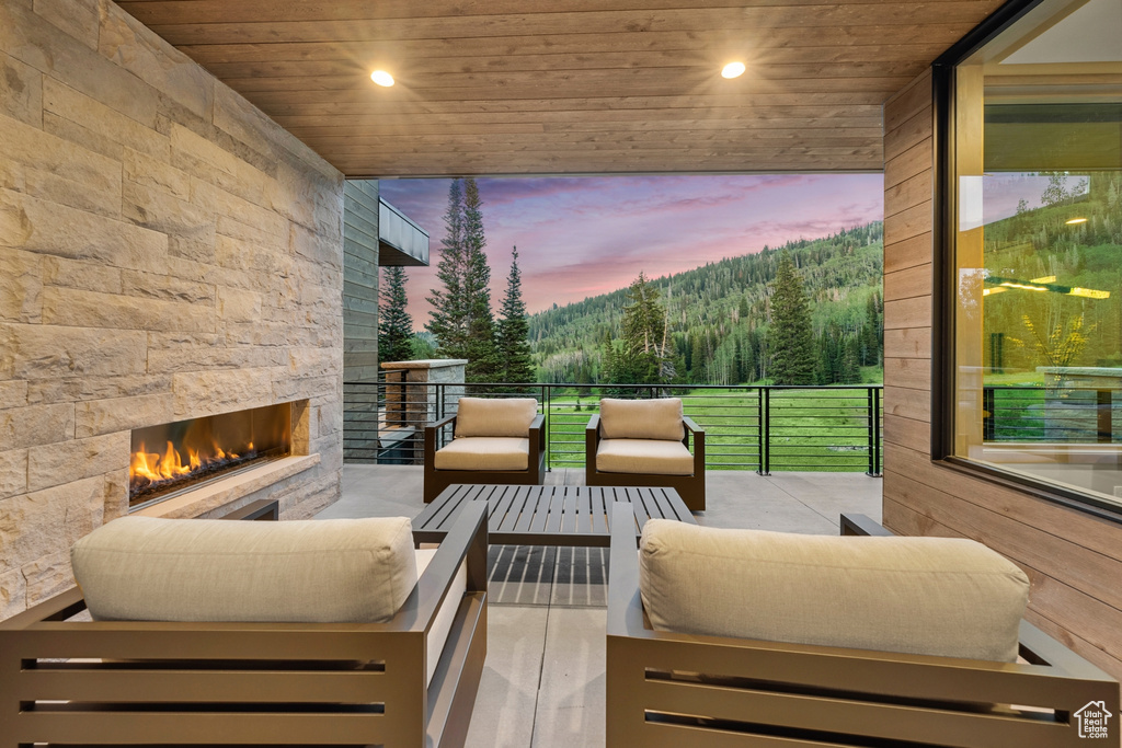 Deck at dusk featuring an outdoor living space with a fireplace