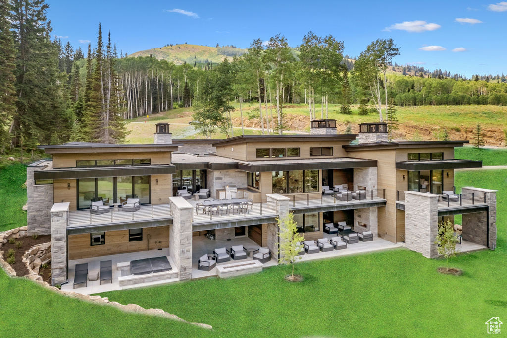 Rear view of property with a balcony, a yard, and a patio area