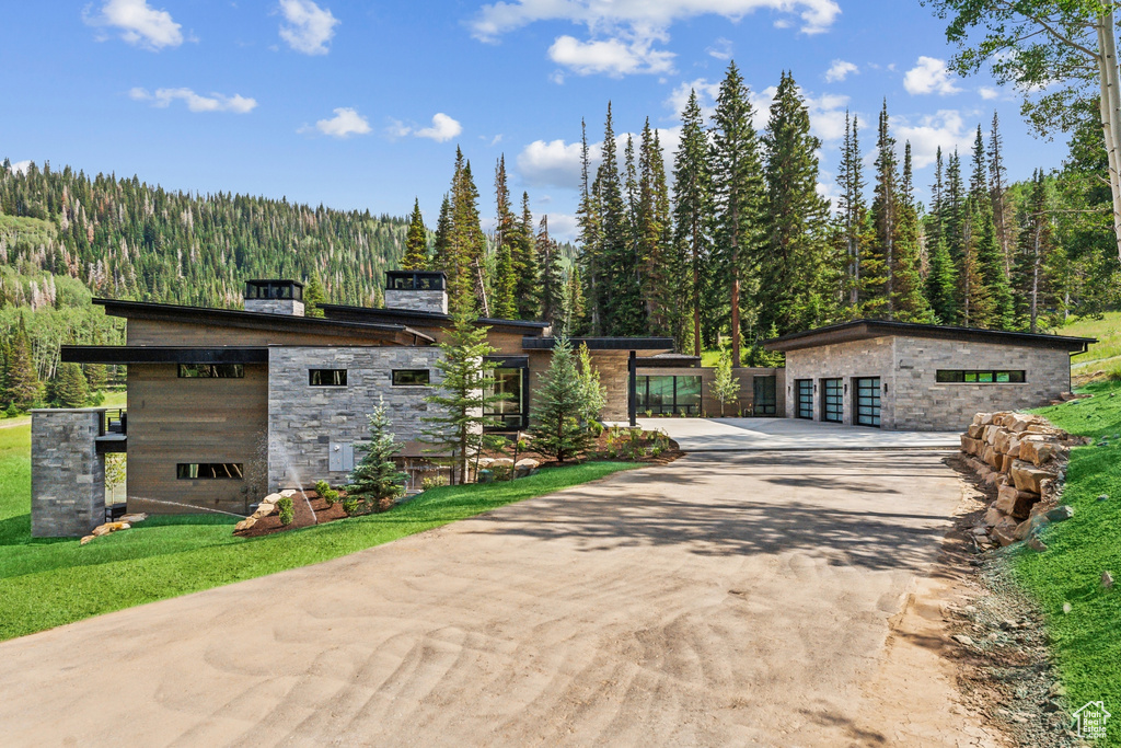 View of front facade featuring an outbuilding, a garage, and a front yard