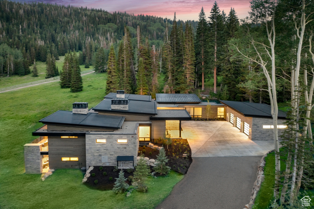 View of front of property with a garage and a lawn