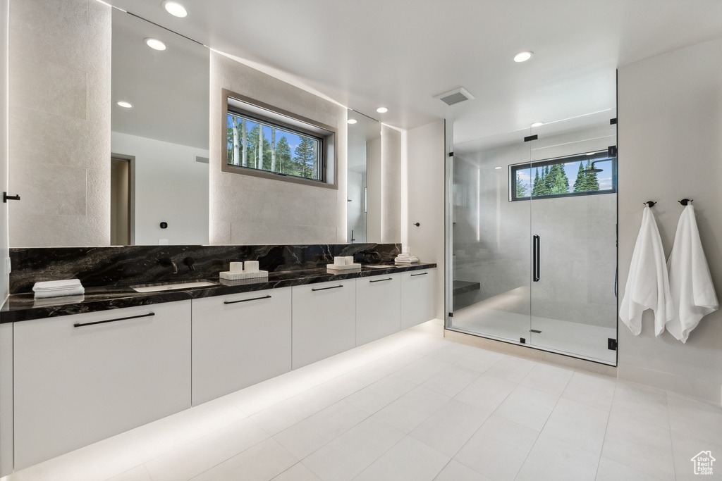 Bathroom with a shower with shower door, vanity, and tile patterned floors