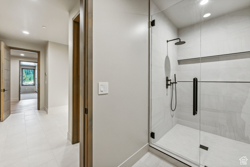 Bathroom featuring tile patterned floors and a shower with shower door