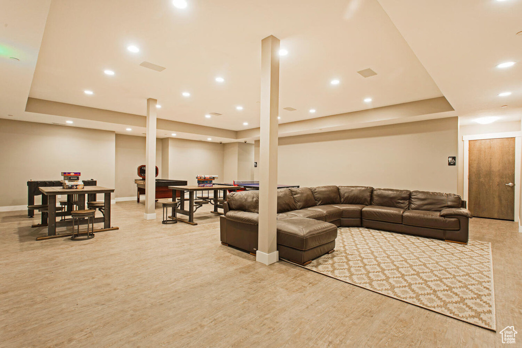 Living room with light hardwood / wood-style flooring and a tray ceiling