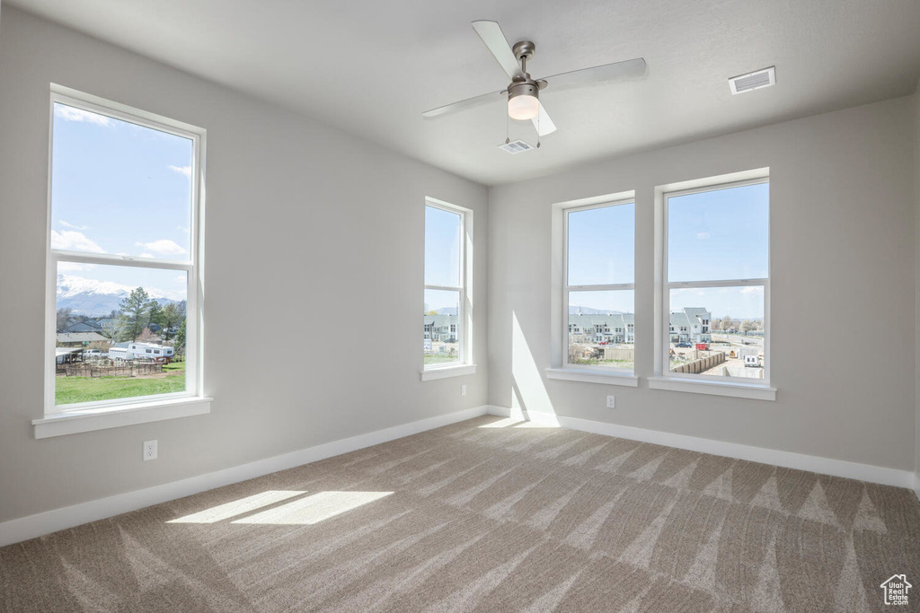 Empty room featuring carpet floors and ceiling fan