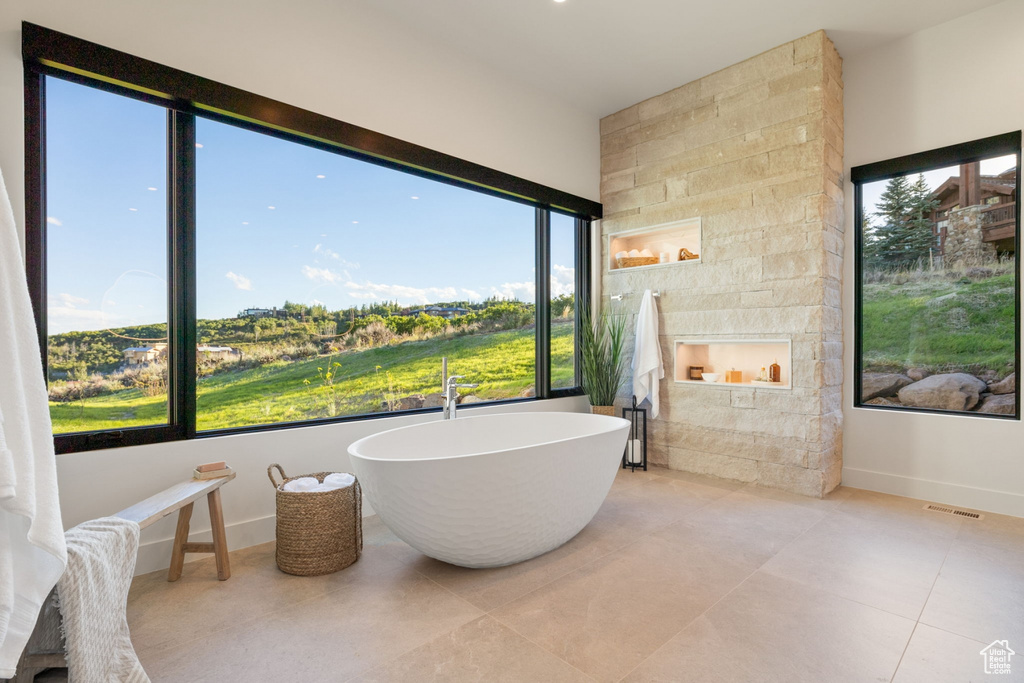 Bathroom with a tub and tile patterned flooring