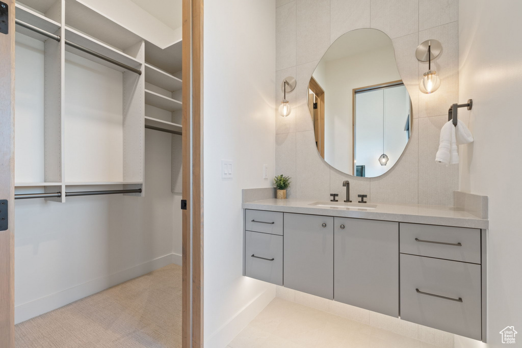 Bathroom featuring tile walls, decorative backsplash, and vanity