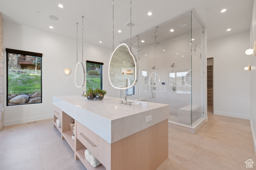 Bathroom with tile patterned flooring, an enclosed shower, and vanity