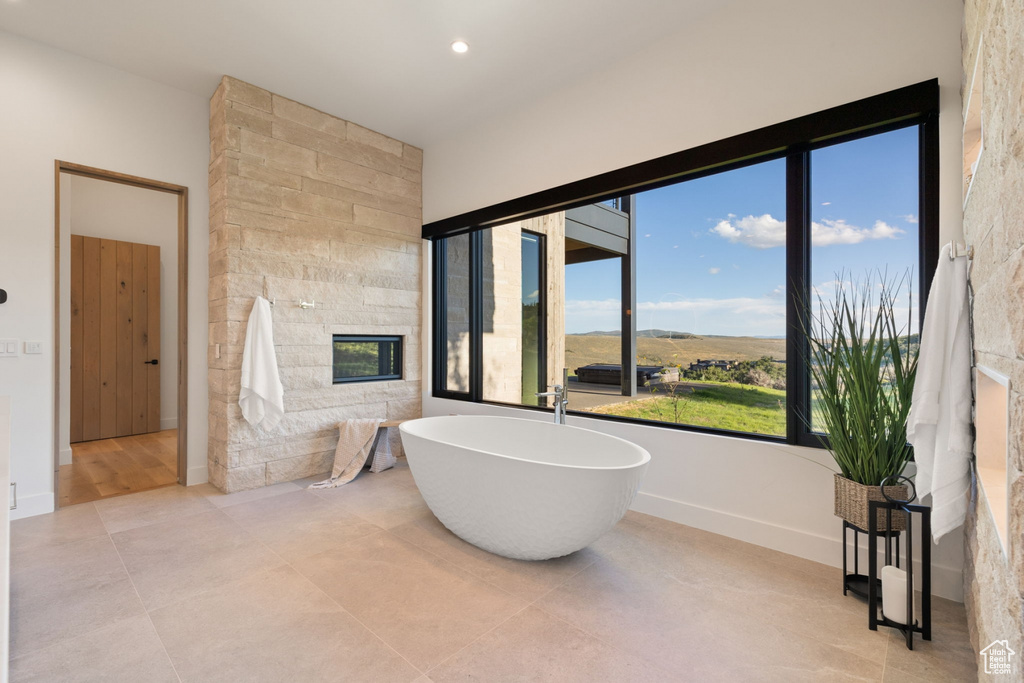 Bathroom featuring tile walls, tile patterned flooring, and a bathtub