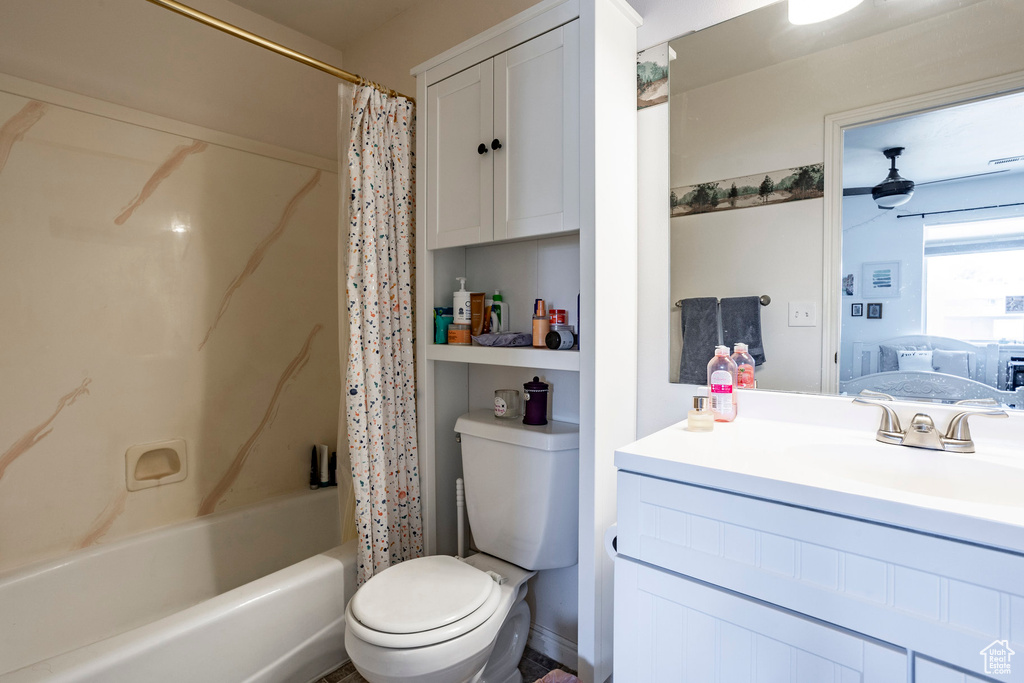 Full bathroom featuring toilet, shower / bathtub combination with curtain, and vanity