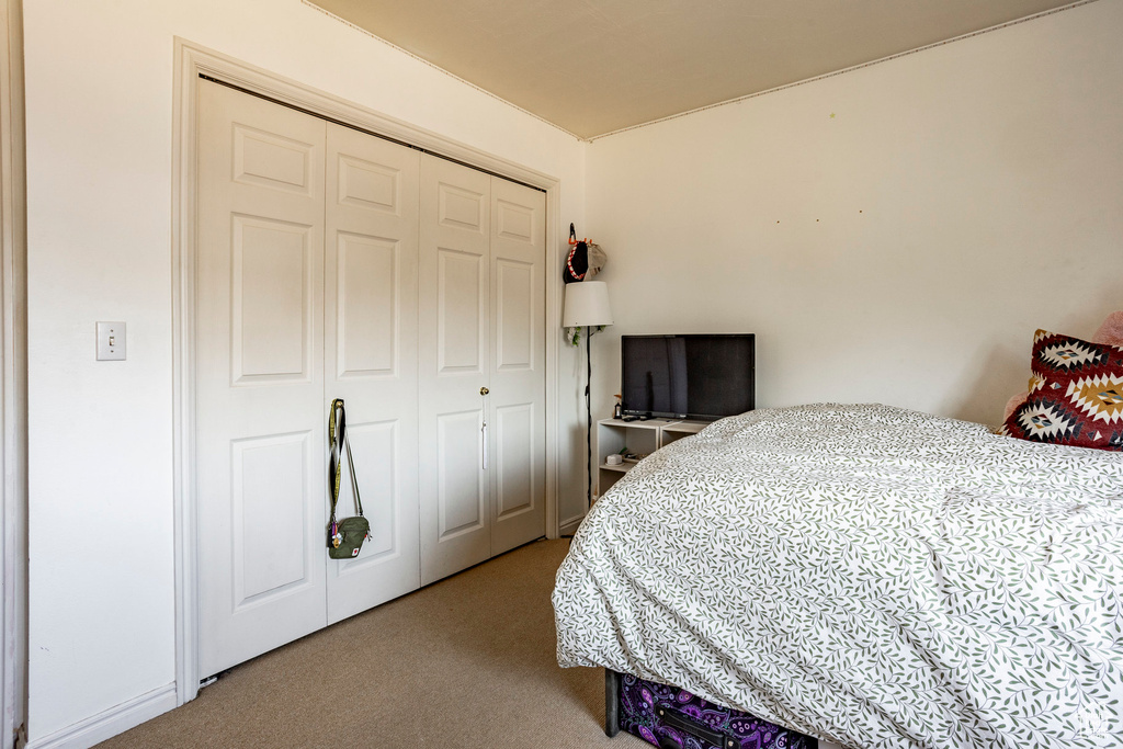 Carpeted bedroom featuring a closet
