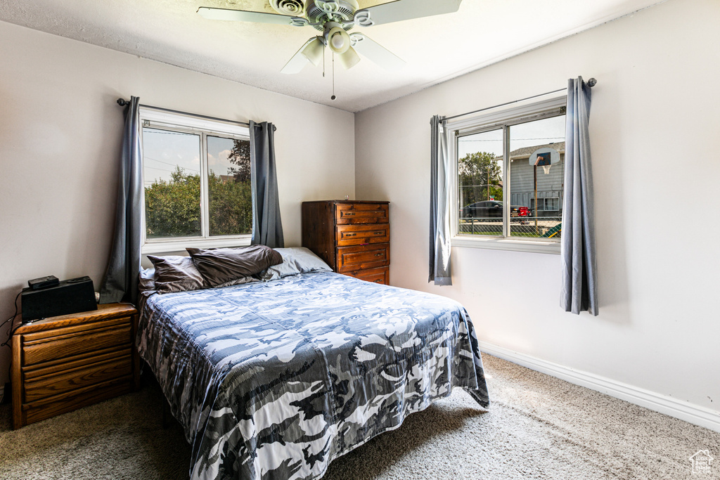 Carpeted bedroom featuring ceiling fan