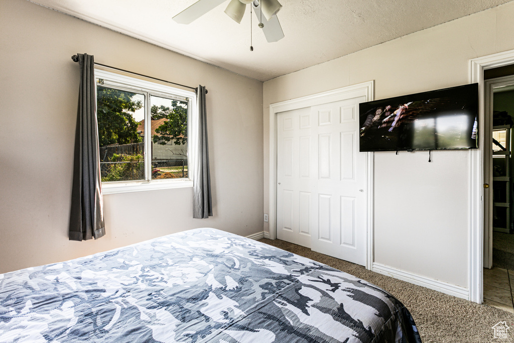 Bedroom with a closet, carpet floors, and ceiling fan