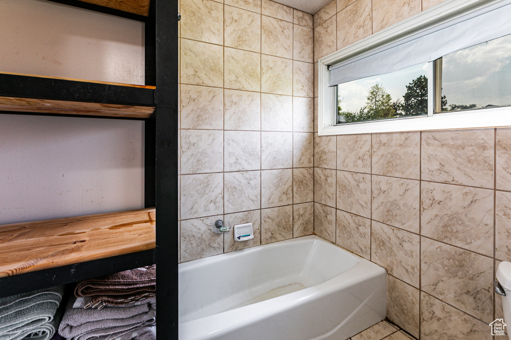 Bathroom with tile patterned floors and tile walls