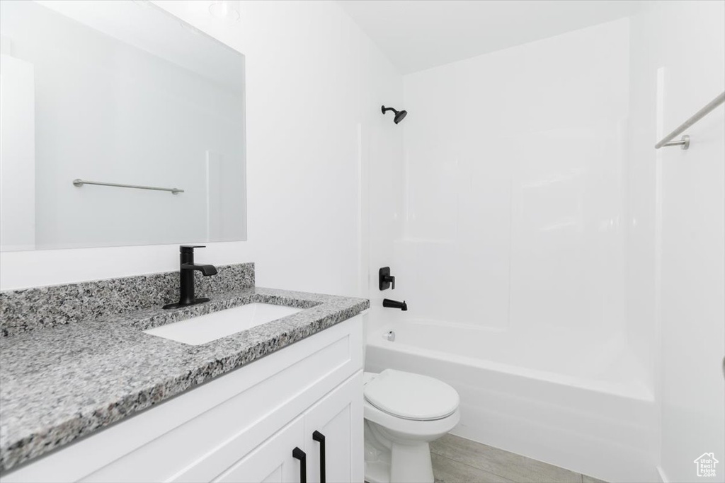 Full bathroom with toilet, tub / shower combination, and vanity