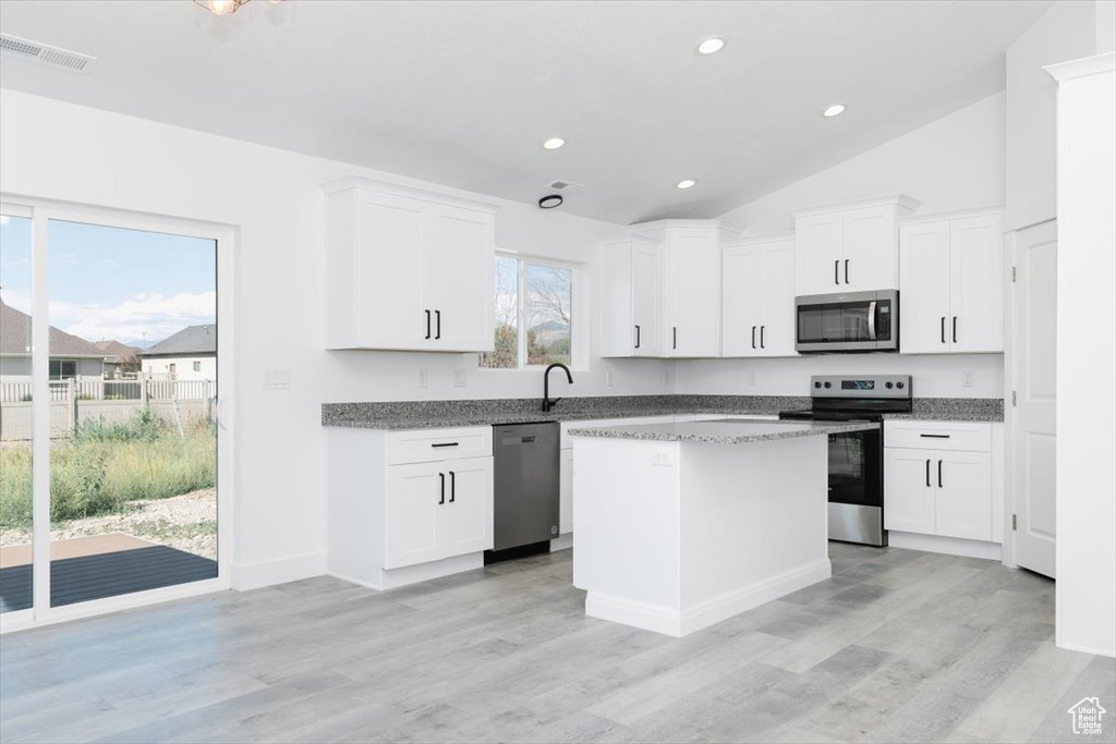 Kitchen with appliances with stainless steel finishes, plenty of natural light, and light hardwood / wood-style flooring