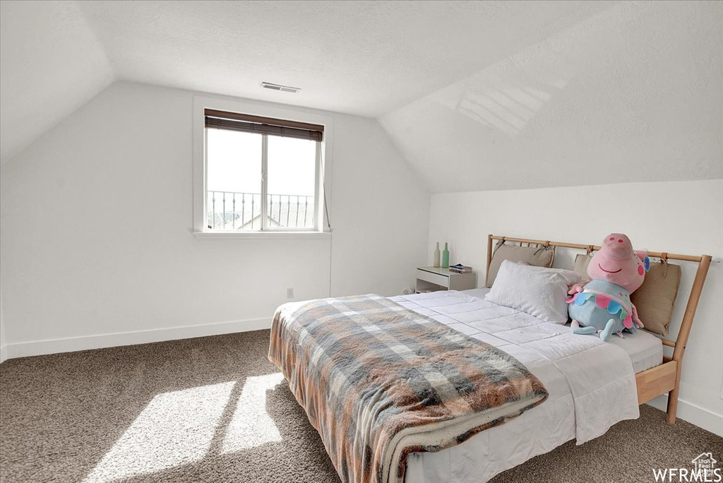 Carpeted bedroom with lofted ceiling