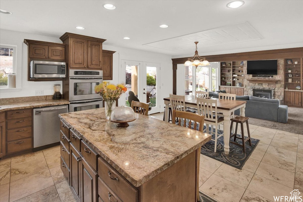 Kitchen with stainless steel appliances, a healthy amount of sunlight, and a center island