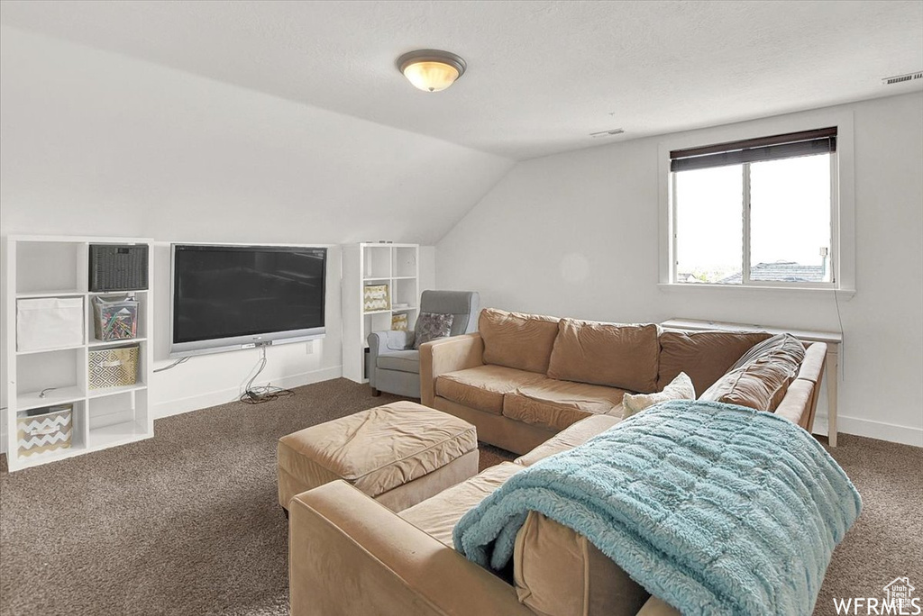 Carpeted living room with vaulted ceiling