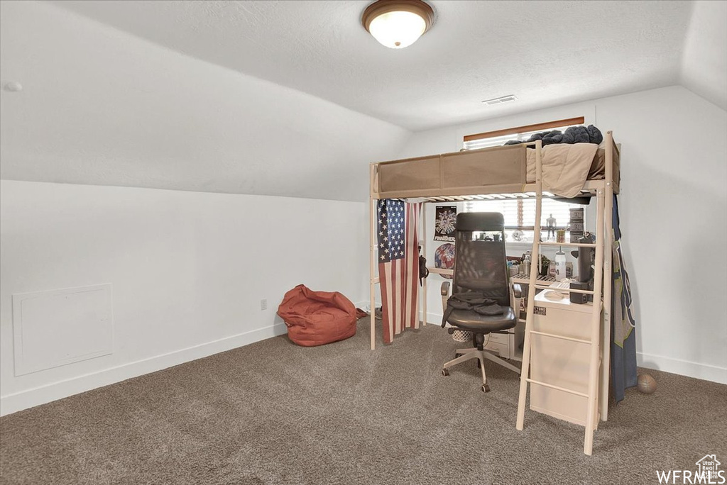 Office area featuring a textured ceiling, carpet, and lofted ceiling