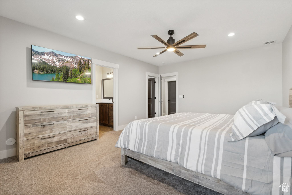 Carpeted bedroom with ceiling fan and connected bathroom