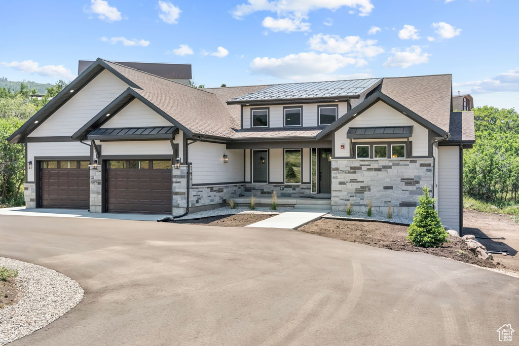 Modern inspired farmhouse with a garage and a porch