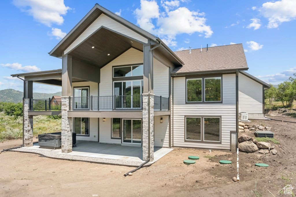 Rear view of property featuring a balcony and a patio area