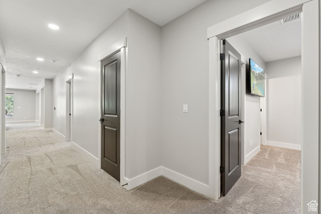 Corridor with light colored carpet