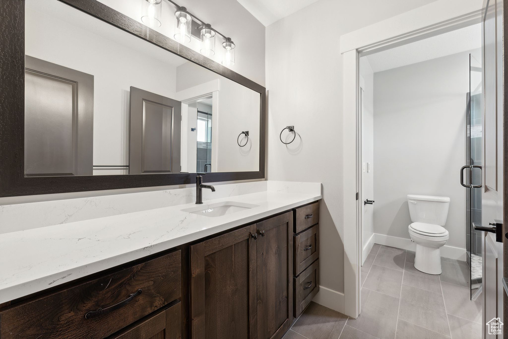 Bathroom featuring tile patterned flooring, toilet, and vanity