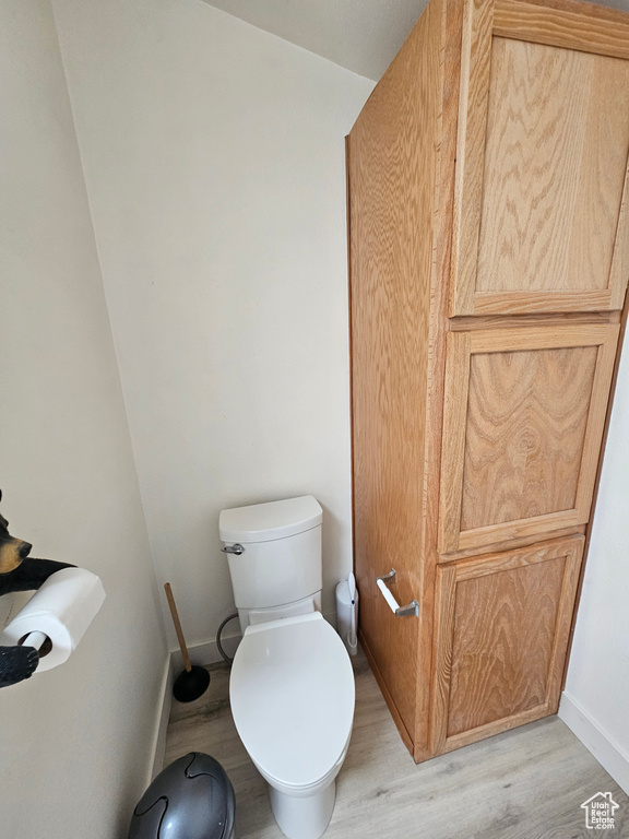 Bathroom with hardwood / wood-style flooring and toilet