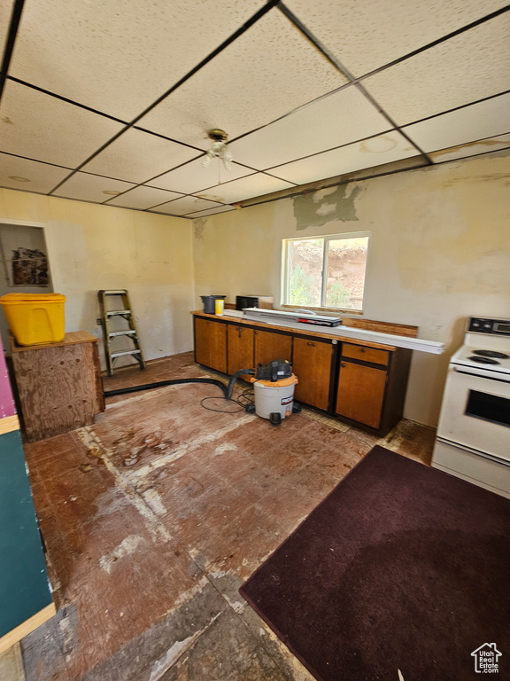 Kitchen featuring a paneled ceiling, ceiling fan, and white electric range oven