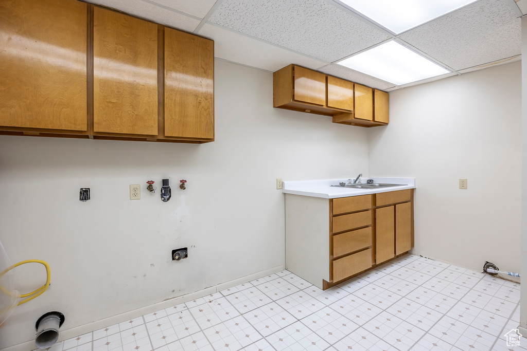 Laundry room featuring cabinets, sink, light tile patterned flooring, and washer hookup