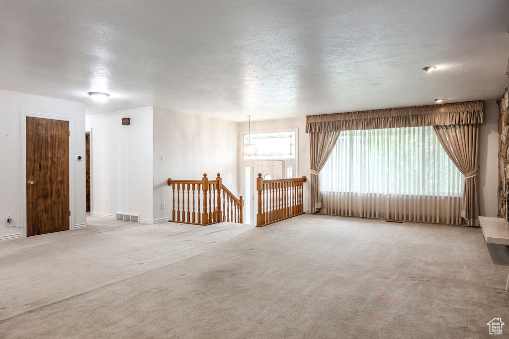 Carpeted empty room featuring a textured ceiling