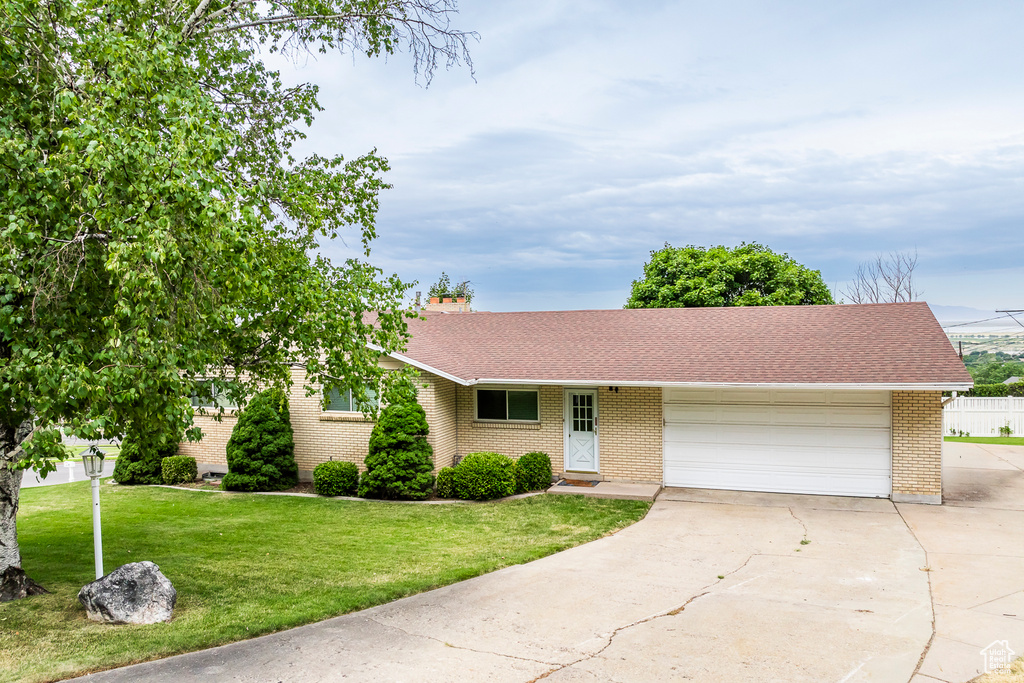 Ranch-style house with a garage and a front yard