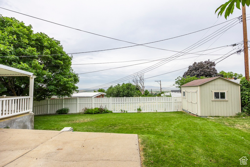 View of yard with a storage shed and a patio area