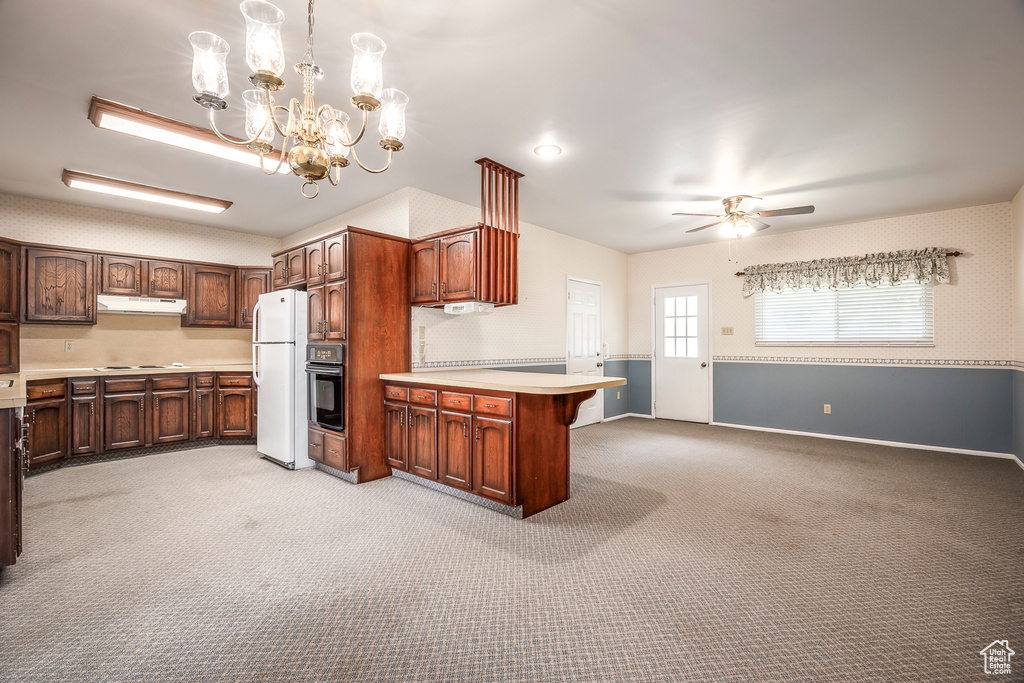 Kitchen featuring oven, light carpet, white refrigerator, and ceiling fan with notable chandelier