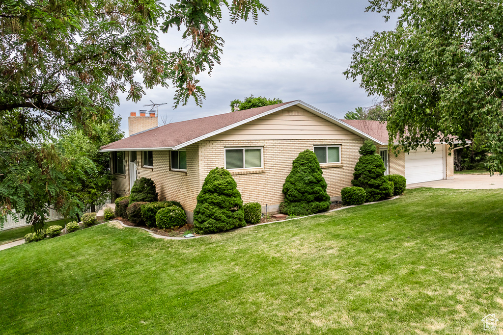 Single story home with a garage and a front yard