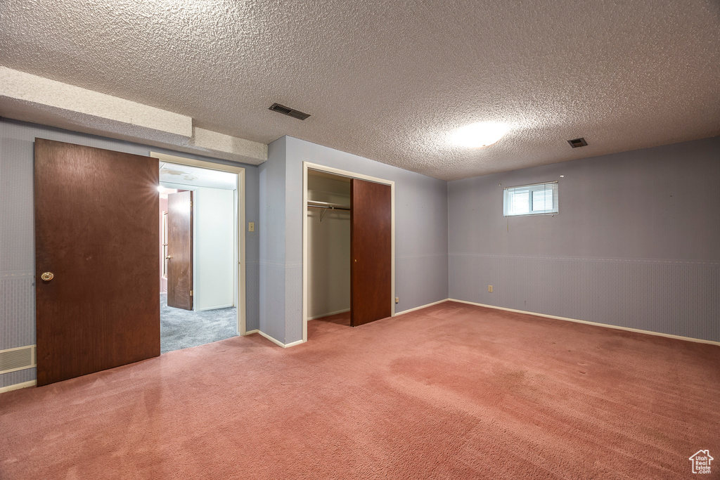 Unfurnished bedroom featuring a closet, carpet, and a textured ceiling